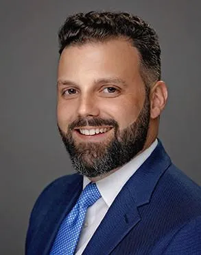 A man with a beard and suit on.