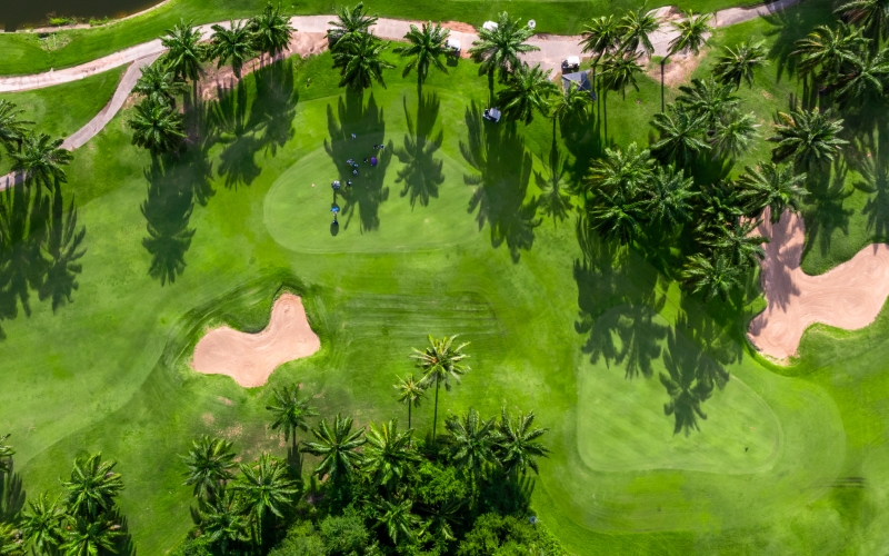 Aerial top view golf course with lush greens, green fairway and sand bunker, Golf course green grass and trees fairway and putting green, Beautiful golf course.