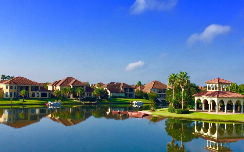 waterfront-homes-reflected-in-water-on-clear-day-2026-03-13-04-14-33-utc